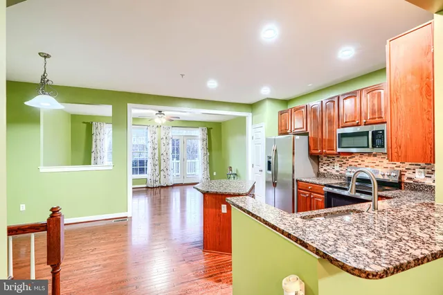 a kitchen with stainless steel appliances granite countertop sink stove and refrigerator