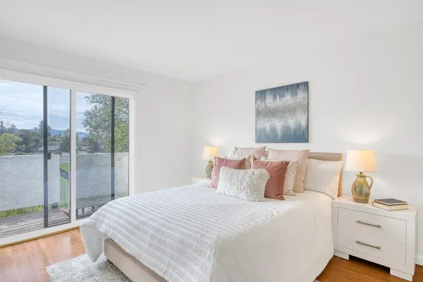 a bedroom with a large bed and a lamp next to a window