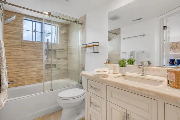 a bathroom with a granite countertop sink toilet and shower