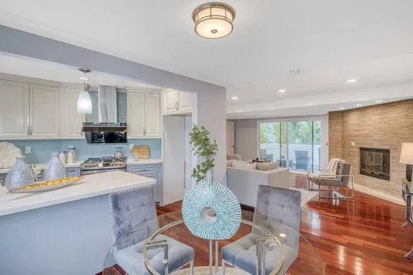 a kitchen with sink refrigerator dining table and chairs