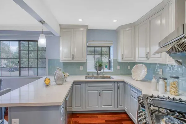 a kitchen with granite countertop a sink stove and cabinets