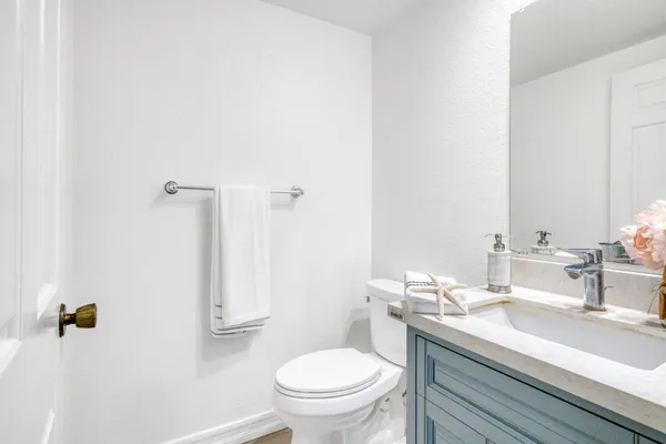 a bathroom with a granite countertop sink a toilet and a mirror