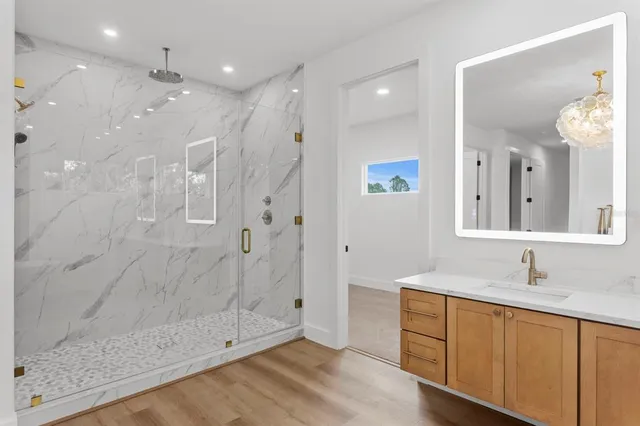 a bathroom with a double vanity sink a large mirror and shower