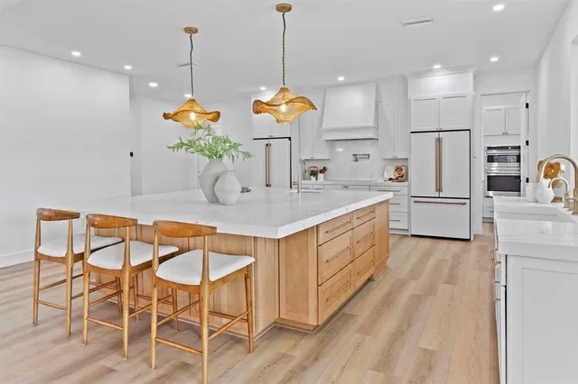 a kitchen with stainless steel appliances kitchen island granite countertop a stove a sink and a refrigerator