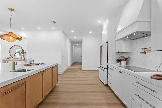 a kitchen with stainless steel appliances a sink stove and cabinets