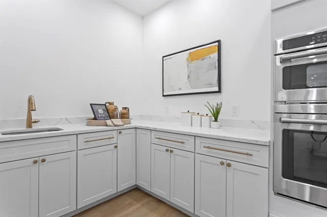 a kitchen with white cabinets and stainless steel appliances