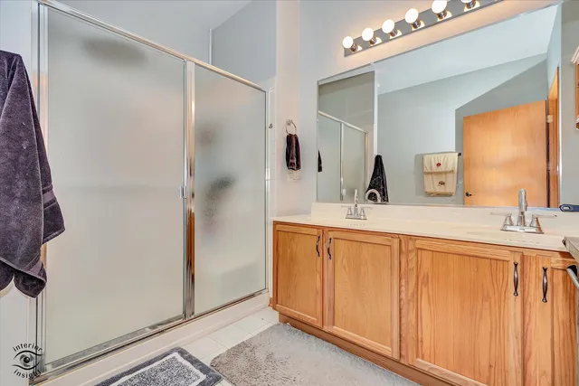 a bathroom with a double vanity sink a mirror and shower