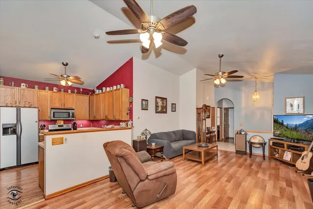 a living room with furniture kitchen view and a chandelier