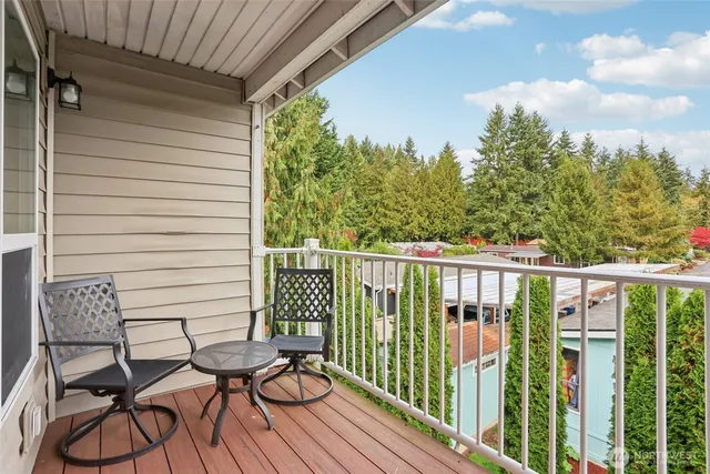 a view of a balcony with chairs and wooden floor