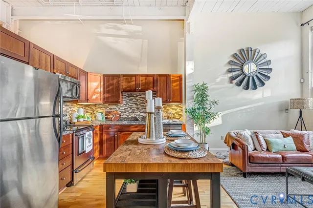 a kitchen with stainless steel appliances granite countertop wooden cabinets a stove and a sink