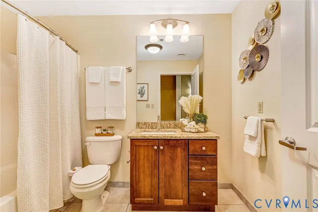 a bathroom with a granite countertop sink a toilet and a mirror