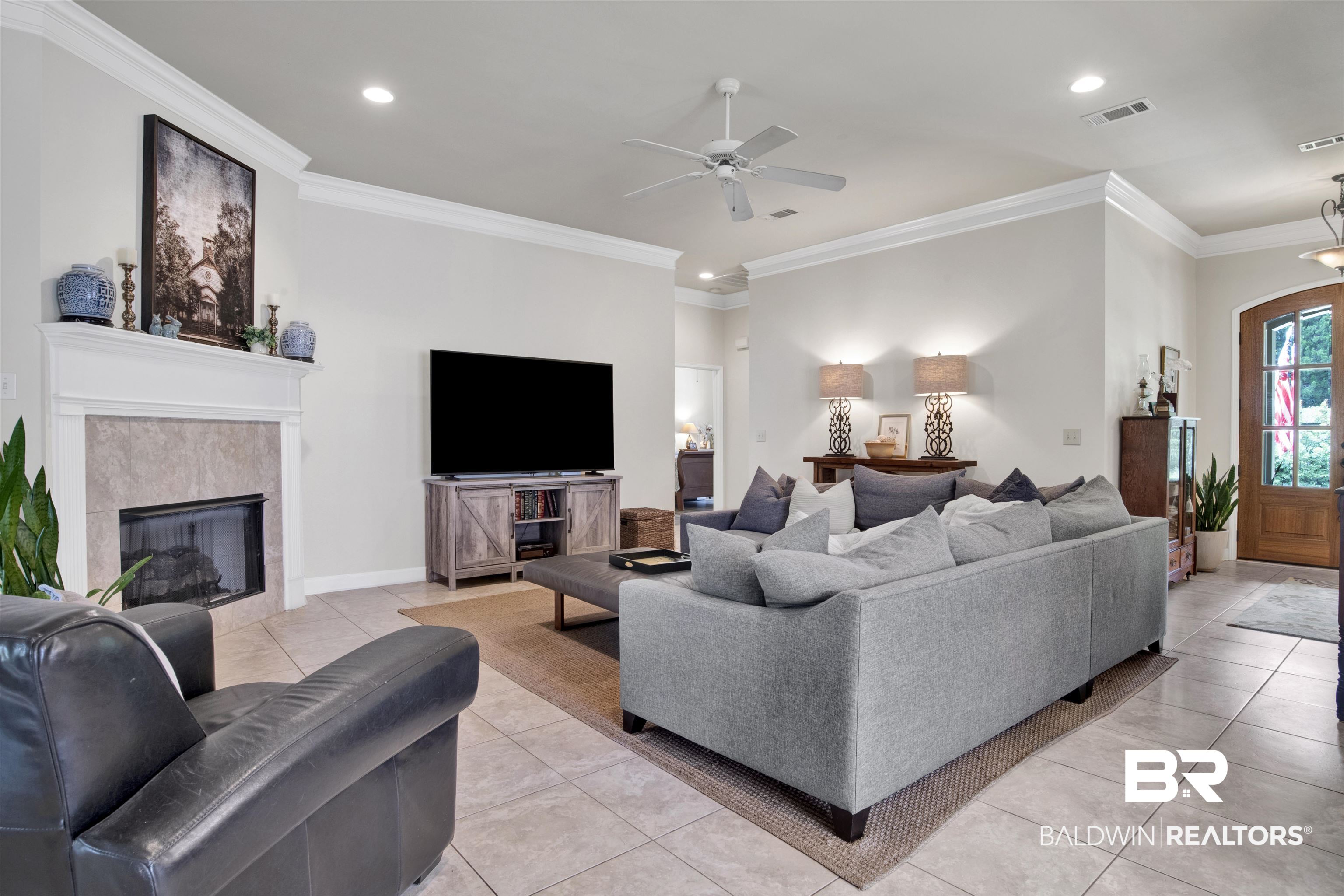 10368 Gayfer Rd Extension Fairhope, AL 36532 - Photo 5 of 43 Spacious living area featuring tile flooring, a fireplace with a mantel and tile surround, and crown molding