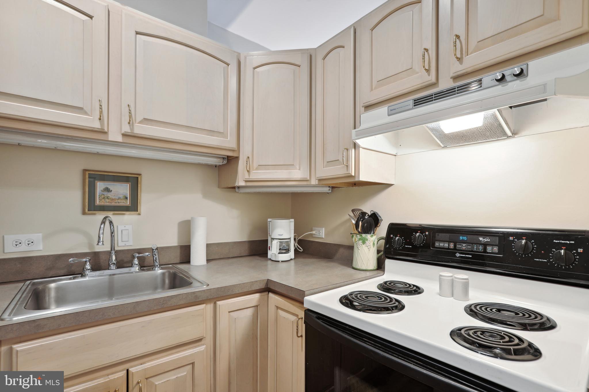 1755 18th Street Northwest, Unit 101 Washington, DC 20009 - Photo 5 of 17 a kitchen with stainless steel appliances granite countertop a sink stove and white cabinets