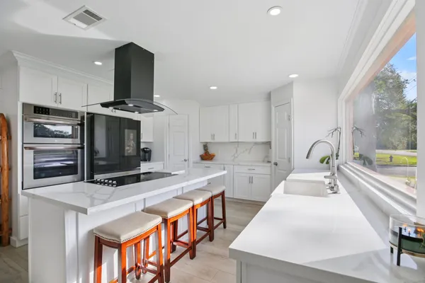a kitchen with stainless steel appliances a stove a sink and a microwave