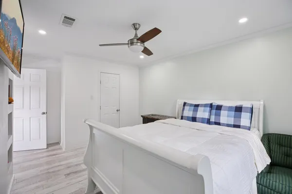 a bedroom with a bed and wooden floor