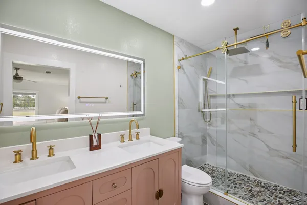 a bathroom with a sink a toilet and shower