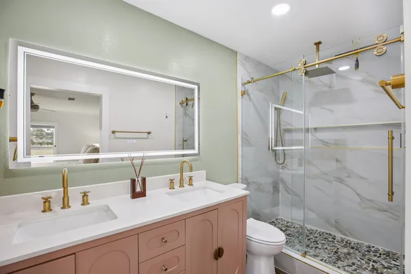 a bathroom with a sink a toilet and shower