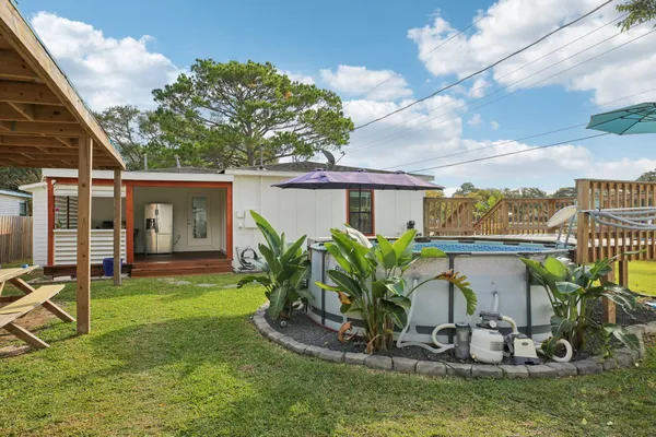 a view of a house with backyard sitting area and tub