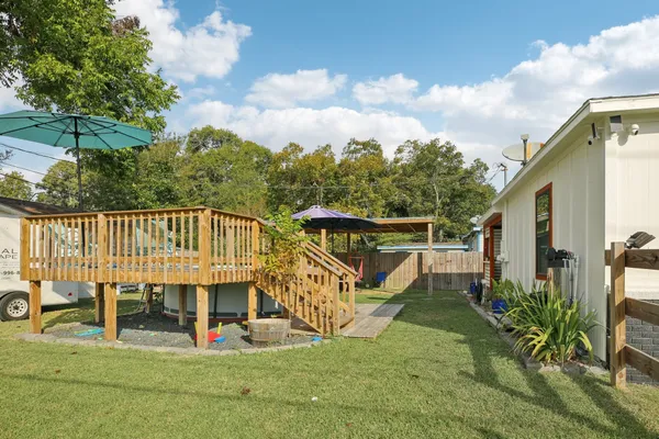 a view of a house with a yard and deck