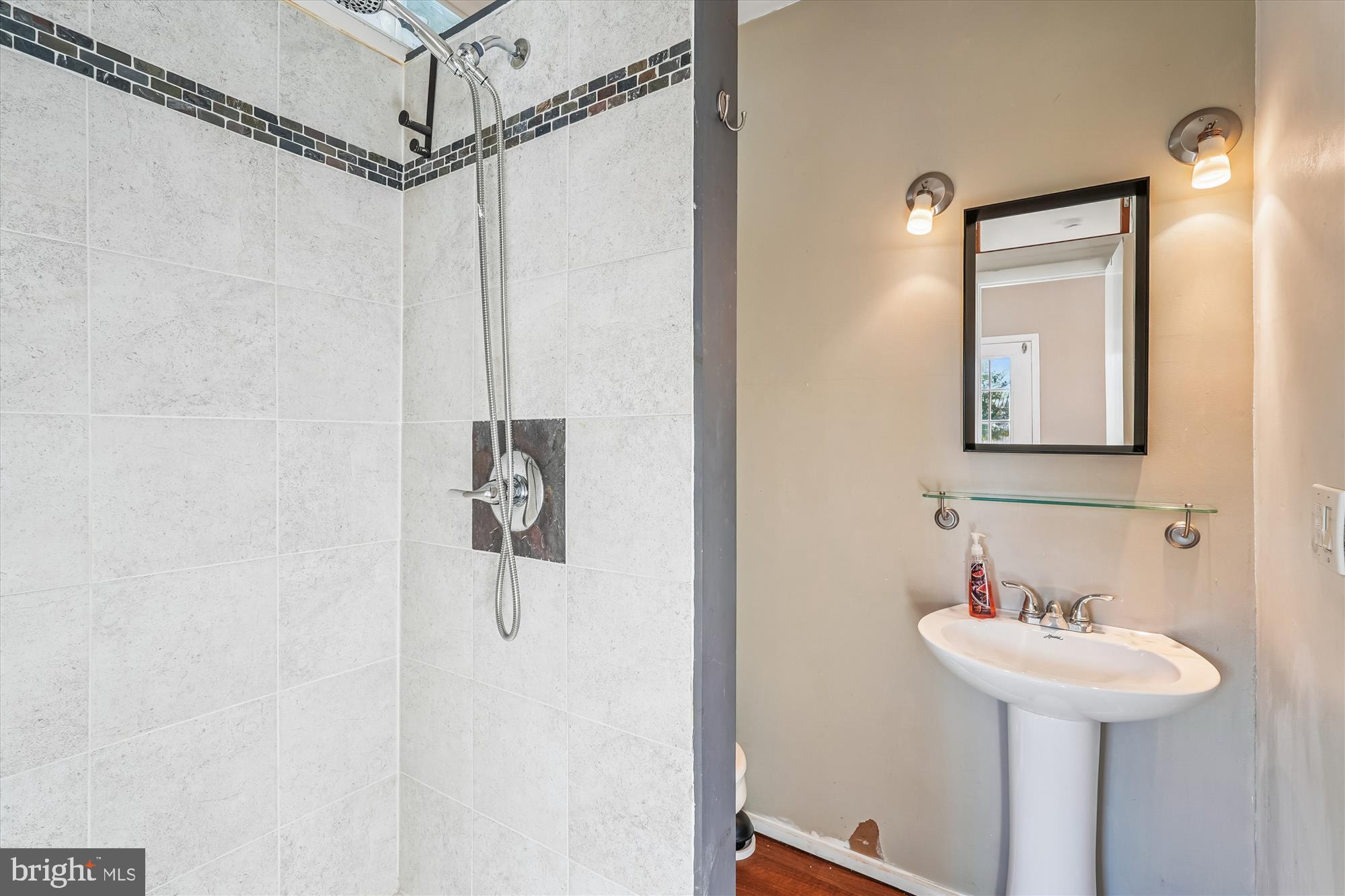 104 Pershing Avenue Northwest Leesburg, VA 20176 - Photo 34 of 36 a bathroom with a sink a mirror a vanity and shower
