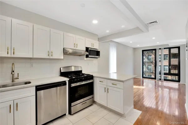 a view of a kitchen with a sink and a refrigerator