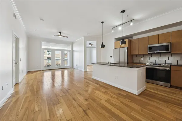 a large kitchen with cabinets wooden floor and a stainless steel appliances