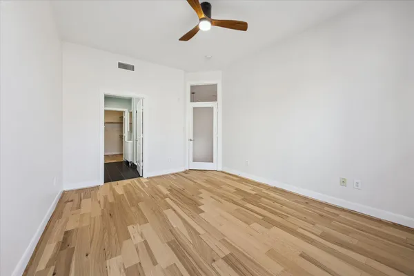 a view of a bedroom with a bed and a chandelier fan