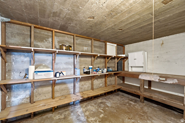 1925 South Main Street Bountiful, UT 84010 - Photo 27 of 48 Utility space with concrete walls and ceiling, featuring built-in wooden shelving and a workbench