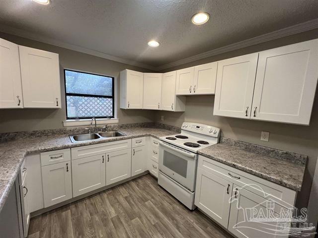 5733 Orange Street Milton, FL 32570 - Photo 3 of 32 a kitchen with granite countertop white cabinets and white appliances