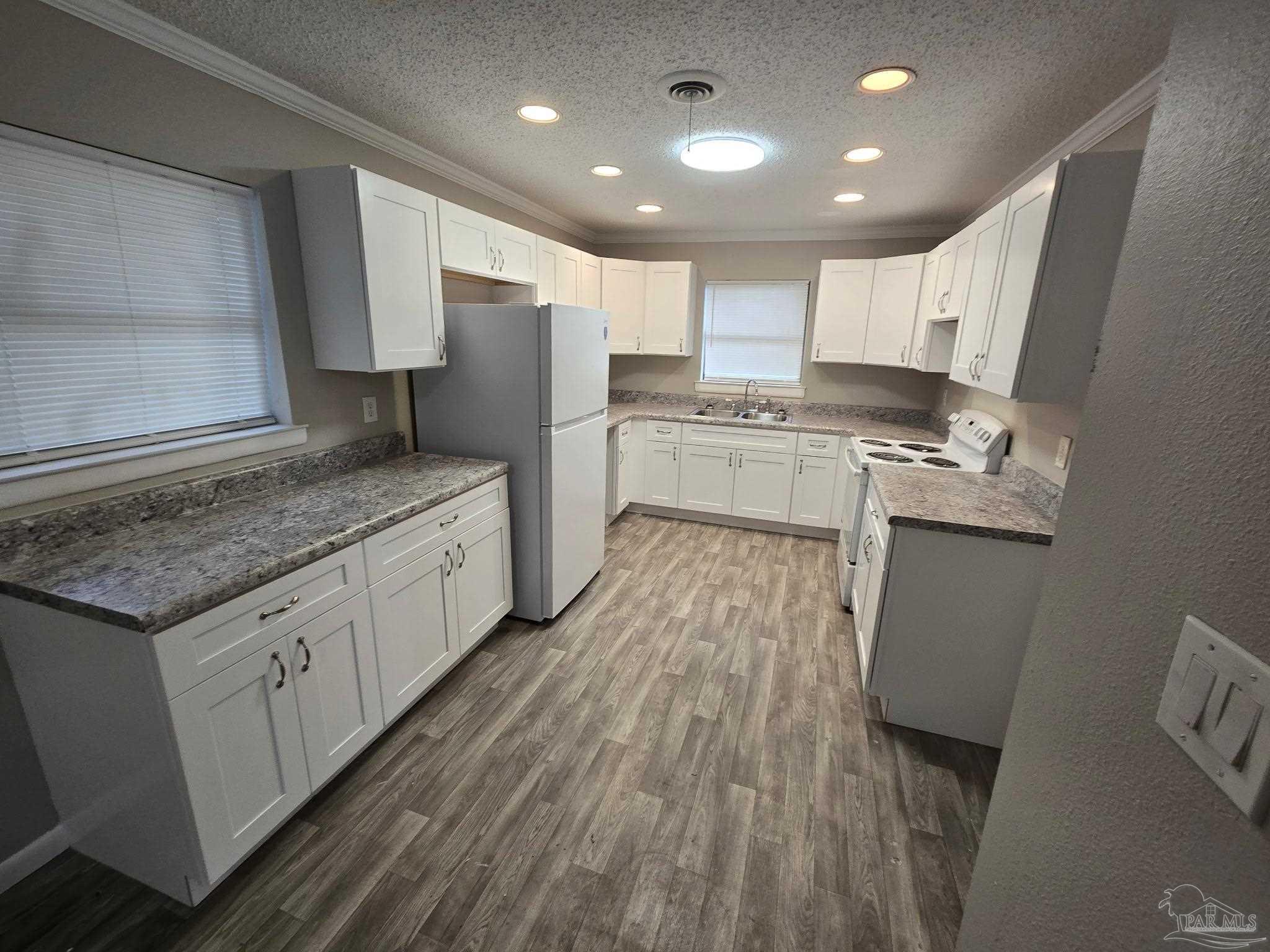 5733 Orange Street Milton, FL 32570 - Photo 32 of 32 a large kitchen with stainless steel appliances granite countertop a lot of counter space and wooden floors