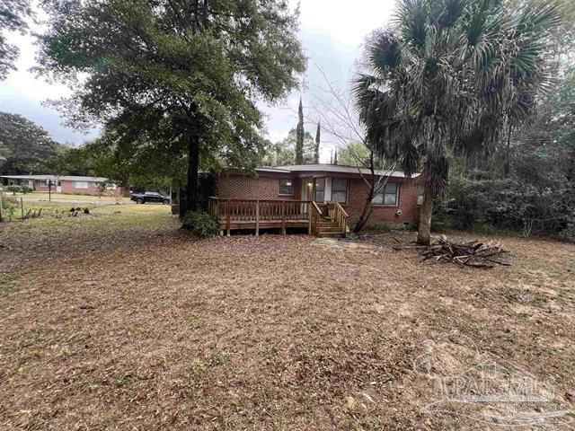 5733 Orange Street Milton, FL 32570 - Photo 6 of 32 a view of backyard with a table and chairs under an umbrella