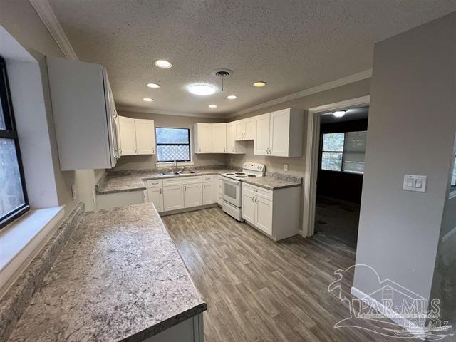 5733 Orange Street Milton, FL 32570 - Photo 7 of 32 a kitchen with stainless steel appliances granite countertop a stove top oven a sink and white cabinets
