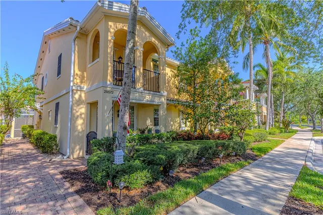 a view of a multi story residential apartment building with yard and green space