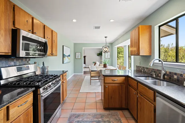 a kitchen with stainless steel appliances granite countertop a stove top oven microwave and cabinets
