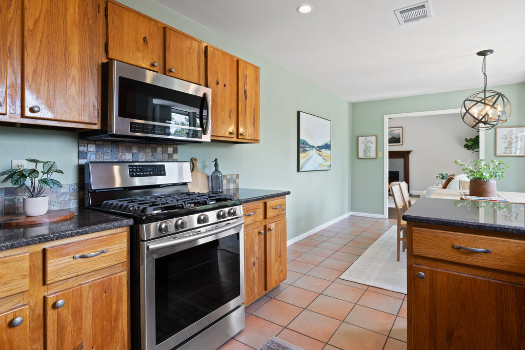 7812 Turquoise Trail Austin, TX 78749 - Photo 15 of 28 a kitchen with stainless steel appliances granite countertop a stove top oven microwave and cabinets