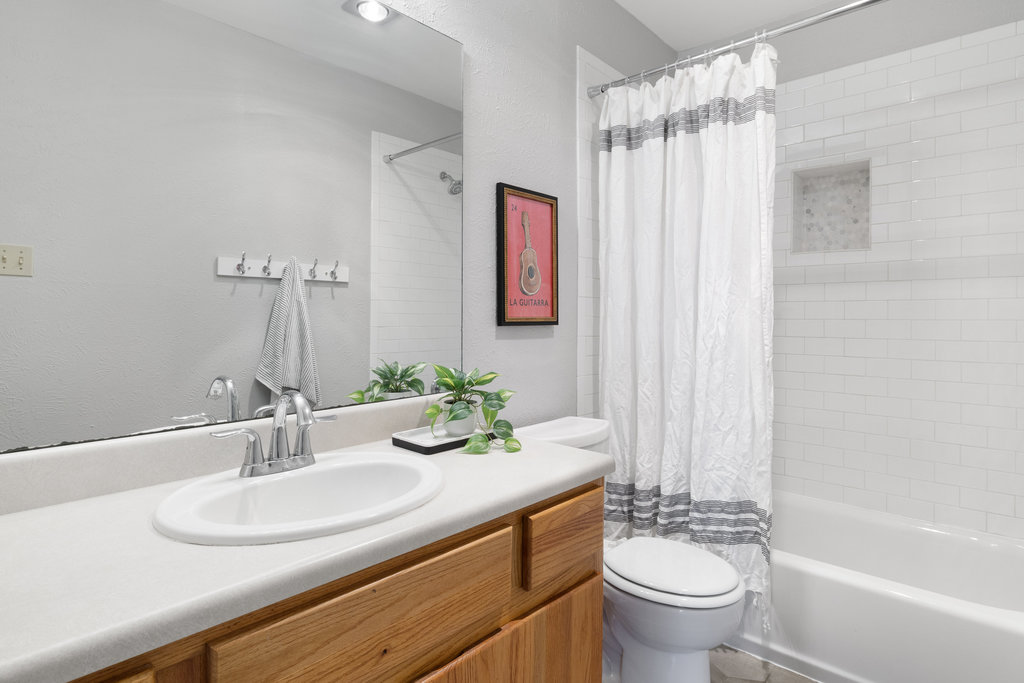 7812 Turquoise Trail Austin, TX 78749 - Photo 23 of 28 a bathroom with a granite countertop sink a toilet a mirror and shower