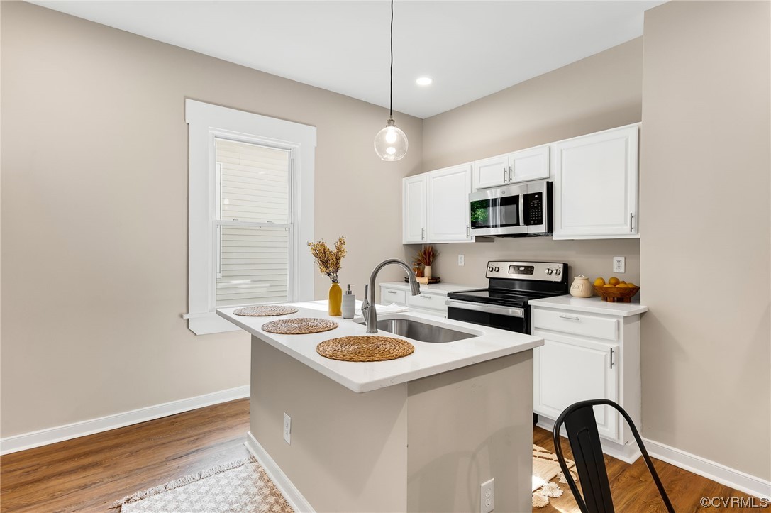 117 Spring Street Petersburg, VA 23803 - Photo 9 of 22 a kitchen with kitchen island a white counter top space a sink and appliances