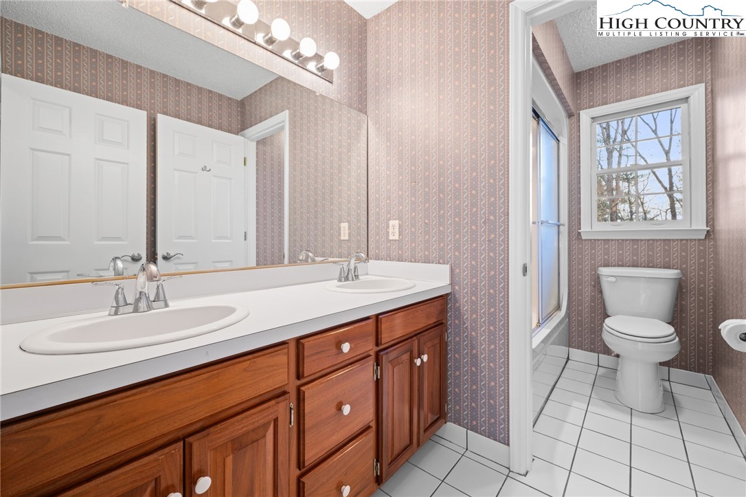 458 Jim Caudill Road Wilkesboro, NC 28697 - Photo 29 of 50 a bathroom with a granite countertop sink a toilet and a mirror