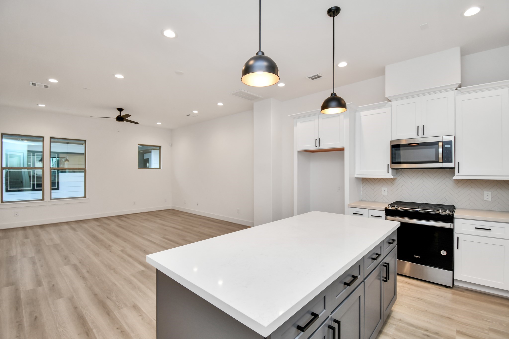 2335 Eagle Street Houston, TX 77004 - Photo 13 of 26 a kitchen with stainless steel appliances a stove a sink a center island a refrigerator and a wooden floor