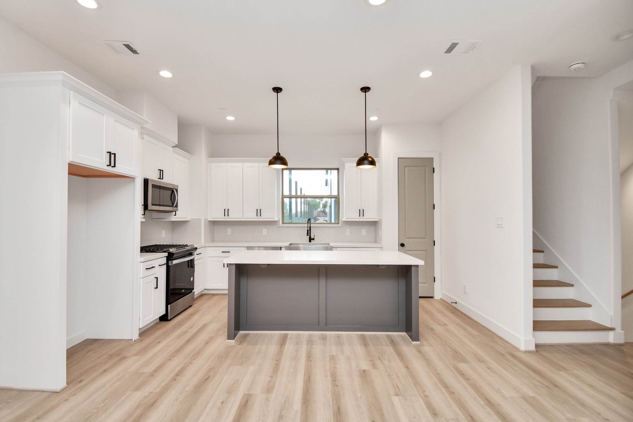 2335 Eagle Street Houston, TX 77004 - Photo 9 of 26 a large kitchen with kitchen island a sink stainless steel appliances and cabinets