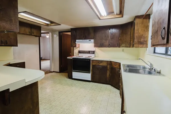 a kitchen with a sink a stove and cabinets