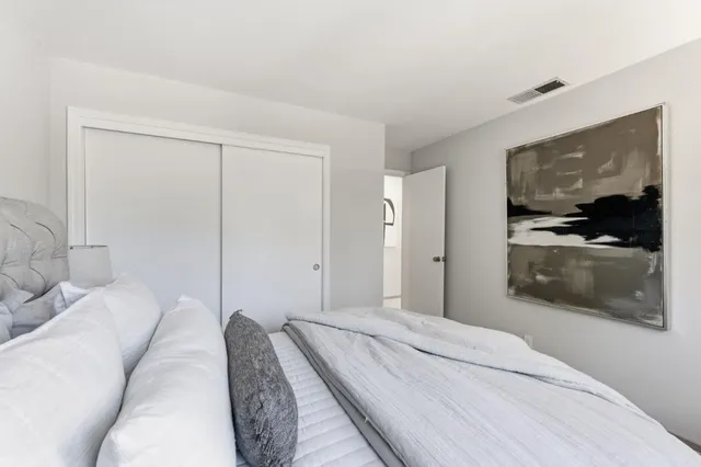 a bedroom with a bed and a large mirror