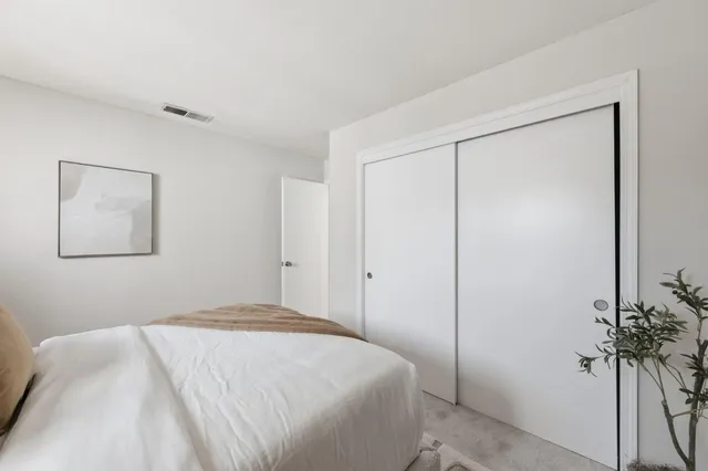 a bedroom with a bed and a potted plant