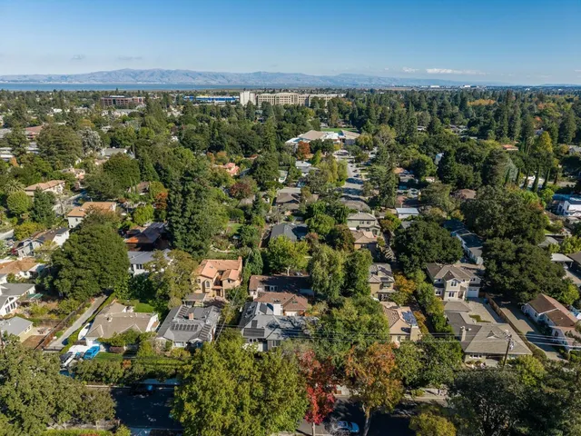 an aerial view of residential houses with outdoor space and trees