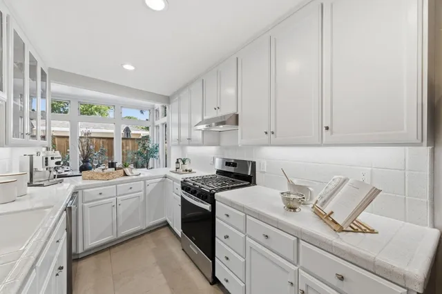 a kitchen with cabinets appliances a sink and a counter top space