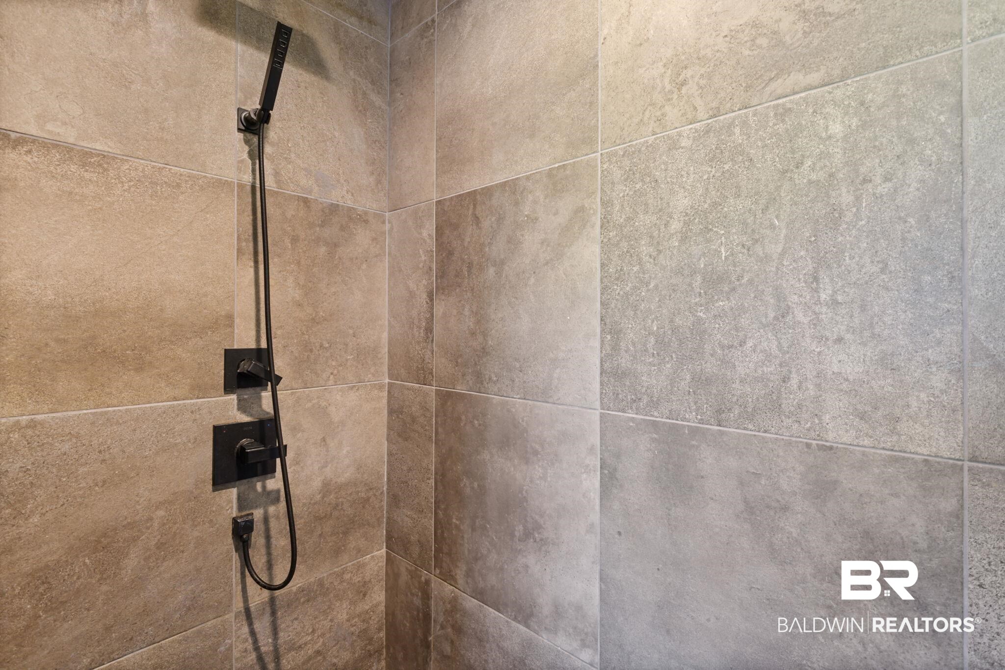 11025 Creax Road Axis, AL 36505 - Photo 27 of 45 Shower enclosure featuring large format stone-look tiles, matte black fixtures, a handheld showerhead, and a wall-mounted control panel