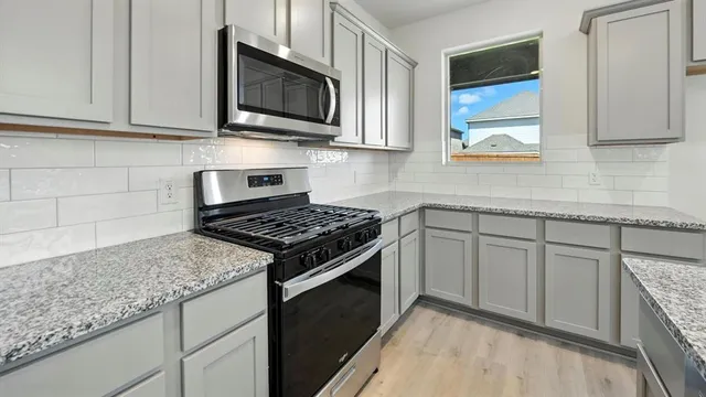 a kitchen with granite countertop cabinets stainless steel appliances and a sink