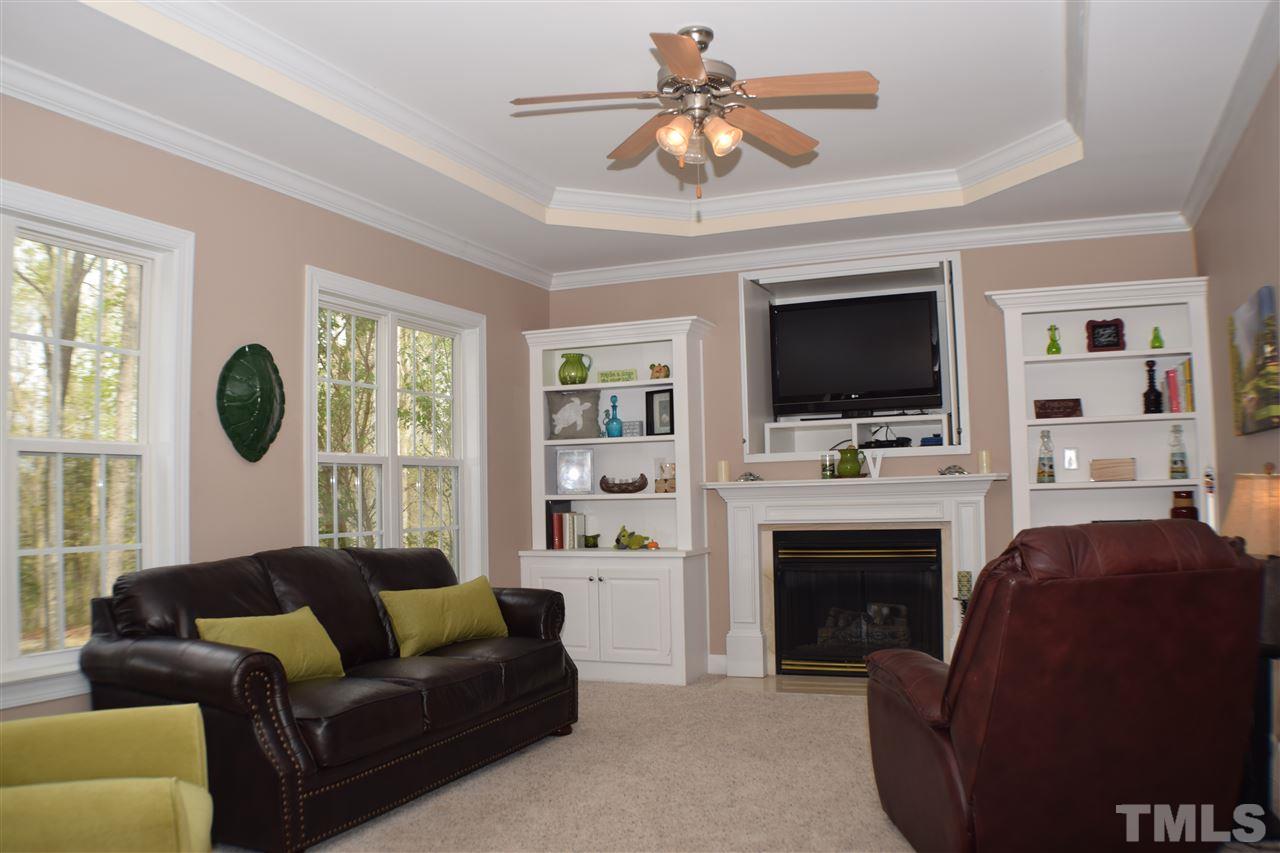 395 Steve Ridge Willow Spring, NC 27592 - Photo 6 of 21 a living room with furniture a fireplace and a flat screen tv
