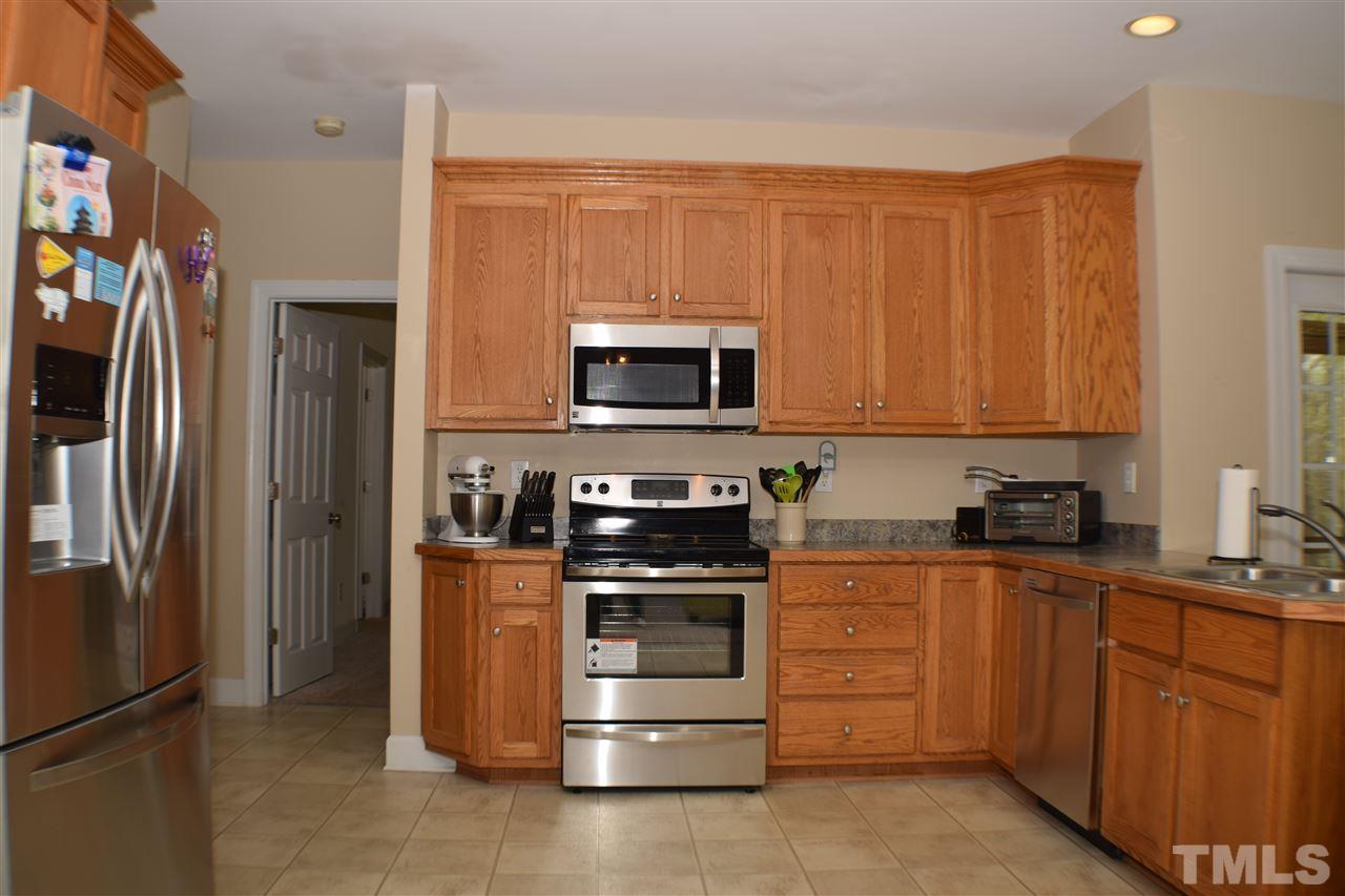 395 Steve Ridge Willow Spring, NC 27592 - Photo 8 of 21 a kitchen with stainless steel appliances granite countertop a stove a refrigerator and a microwave