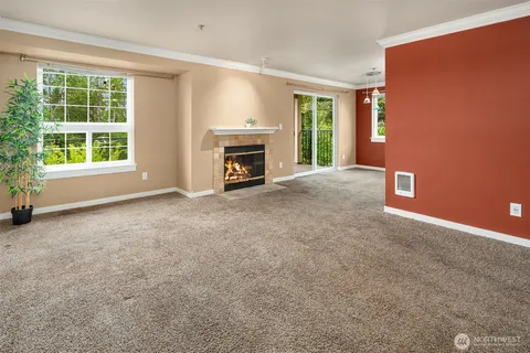 a view of an empty room with a fireplace and a window